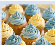 Cupcakes with soft blue and yellow buttercream swirls